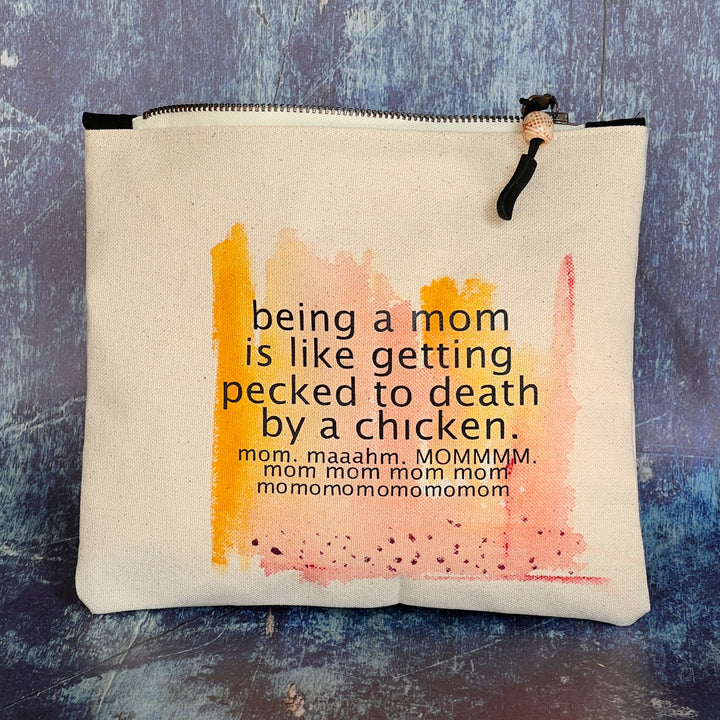 canvas zip bag measuring 9x7 inches, with orange yellow and rose watercolor paints and the words, "being a mom is like getting pecked to death by a chicken. mom. maahm. MOMMMMM!" in black lettering.