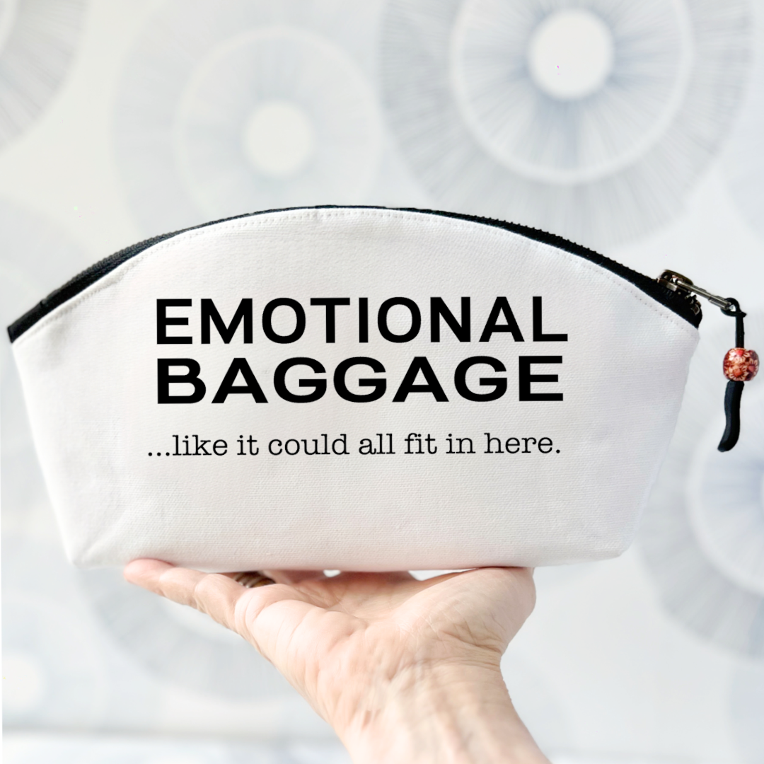 a white canvas zip bag with a curvy top, black zipper and the words, emotional baggage...like it could all fit in here.