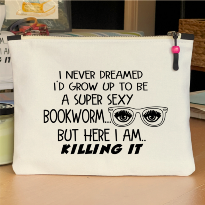 9x7 inch canvas bag with a zipper pull, watercolor paint swashes and the words, "I never dreamed I'd grow up to be a super sexy bookworm..but here I am..killing it."