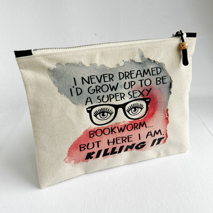 a square, linen-colored canvas zip bag, hand-sewn and hand-painted, with the words, I never dreamed I'd grow up to be a super sexy bookworm, but here I am, killing it.