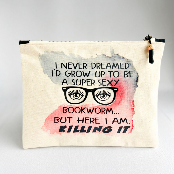 a square, linen-colored canvas zip bag, hand-sewn and hand-painted, with the words, I never dreamed I'd grow up to be a super sexy bookworm, but here I am, killing it.