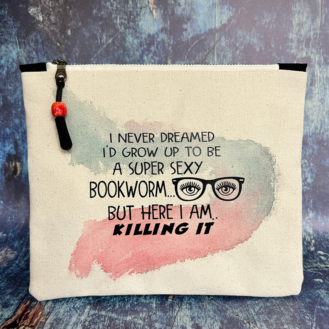 9x7 inch canvas bag with a zipper pull, watercolor paint swashes and the words, "I never dreamed I'd grow up to be a super sexy bookworm..but here I am..killing it."