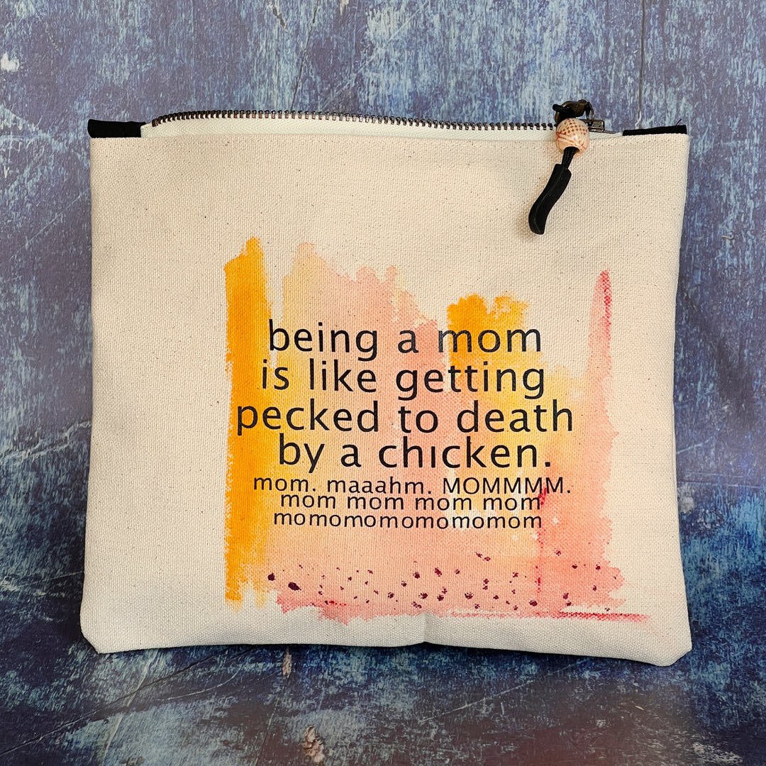 canvas zip bag measuring 9x7 inches, with orange yellow and rose watercolor paints and the words, "being a mom is like getting pecked to death by a chicken. mom. maahm. MOMMMMM!" in black lettering.