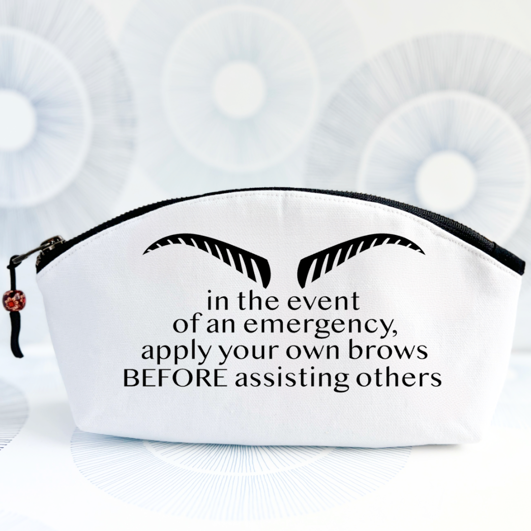 white canvas bag with black zipper, strong eyebrows and the words, in the event of an emergency, apply your own brows BEFORE assisting others