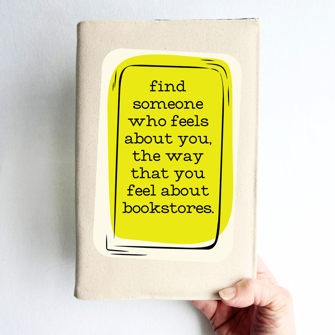 a hand holding a book covered with a linen-color reusable, readjustable book cover.  A yellow square background has the words, 'find someone who feels about you, the way that you feel about bookstores' in black lettering.