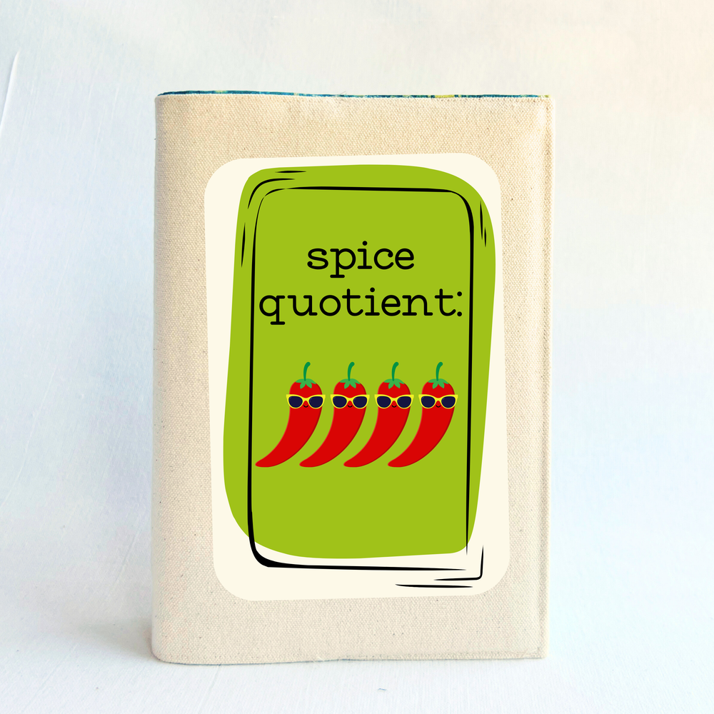 a book covered in linen-color reusable canvas adjustable book cover. A bright green square is the background for the words, 'spice quotient' in black lettering. Four cartoon peppers with sunglasses are layered on top.
