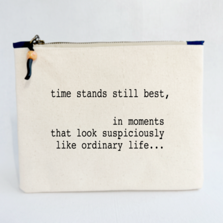 rectangular canvas bag with a zipper pull, in linen-colored duck cloth canvas. The words, time stands still best, in moments that look suspiciously like ordinary life...are lettered in black