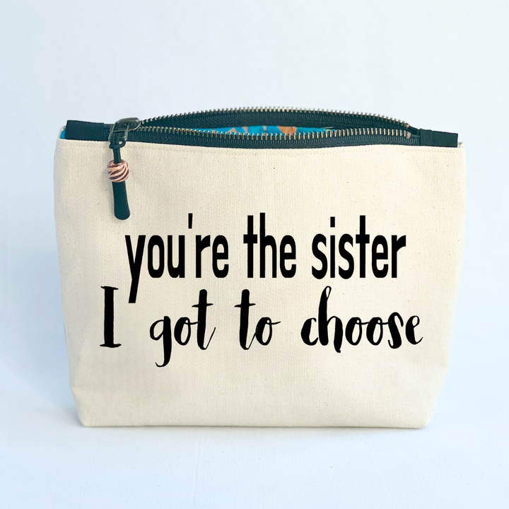 square linen-color canvas bag with black zipper and the words, you're the sister I got to choose
