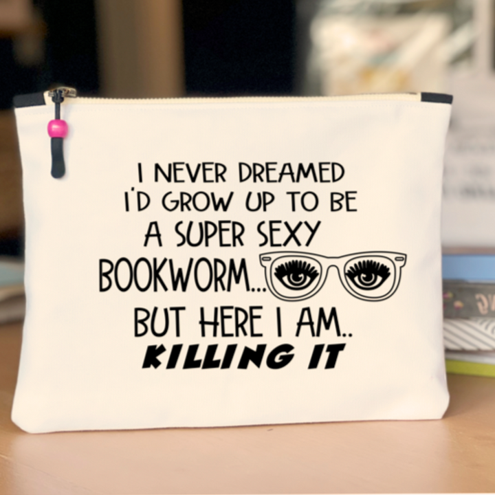 9x7 inch canvas bag with a zipper pull, watercolor paint swashes and the words, "I never dreamed I'd grow up to be a super sexy bookworm..but here I am..killing it."