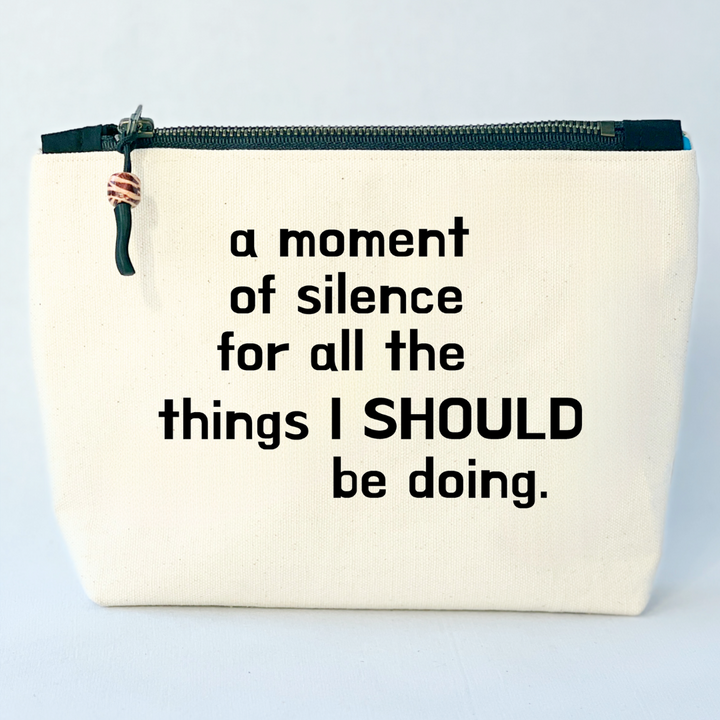 a square linen-color canvas zip bag with a black zipper and the words, a moment of silence for all the things I SHOULD be doing.