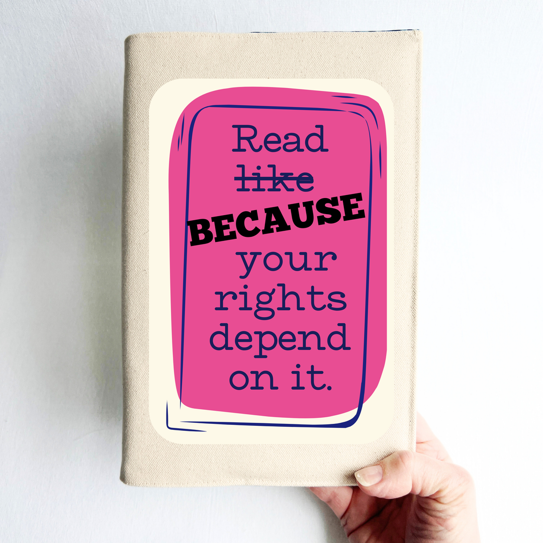 Canvas, reusable book cover in linen, with the words,  'Read like (because) your rights depend on it' in navy lettering on a pink box design.