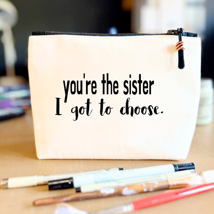 square linen-color canvas bag with black zipper and the words, you're the sister I got to choose