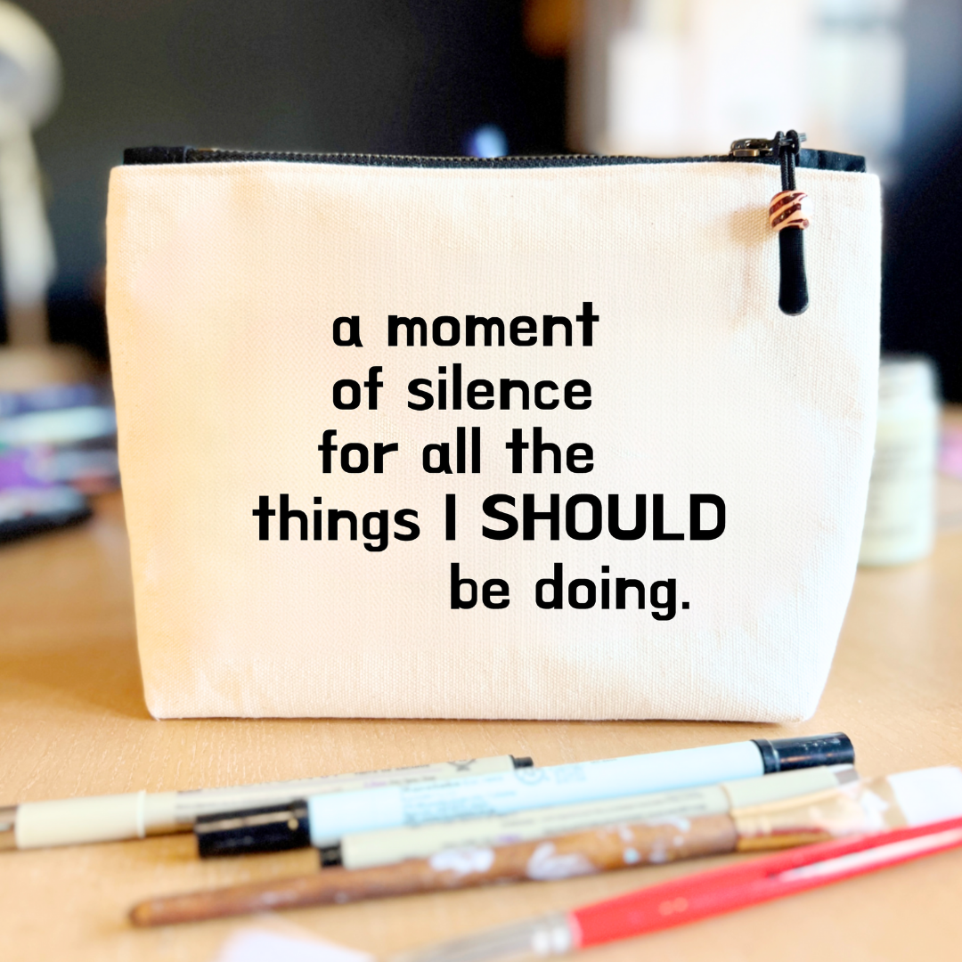 a square linen-color canvas zip bag with a black zipper and the words, a moment of silence for all the things I SHOULD be doing.