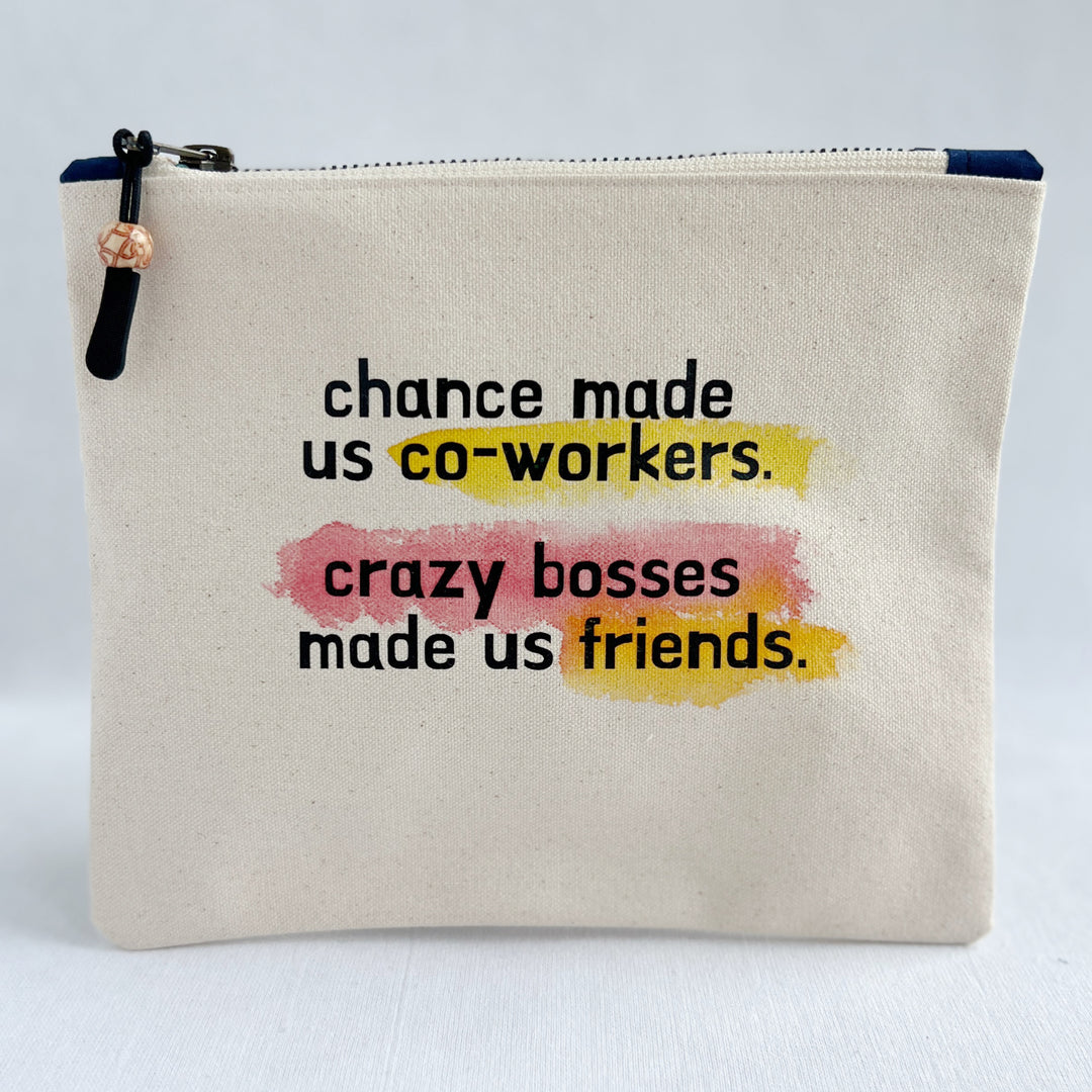 square canvas zip bag with the words, chance made us co-workers, crazy bosses made us friends. painted with swashes of red and yellow.