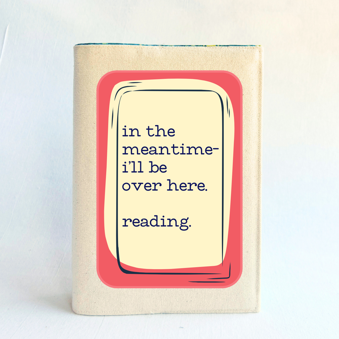 a rectangular linen-colored canvas book cover with a rose graphic topped by a cream square and the words, 'in the meantime, I'll be over here reading.