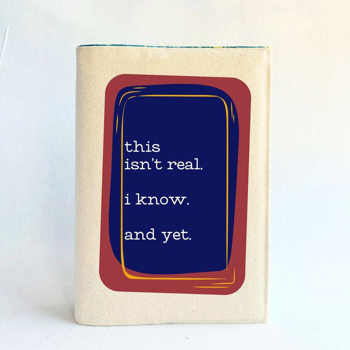 a linen-colored canvas book cover with a graphic design on the cover. The design features a dark blue central rectangle with white text reading 'this isn't real. I know. And yet.'