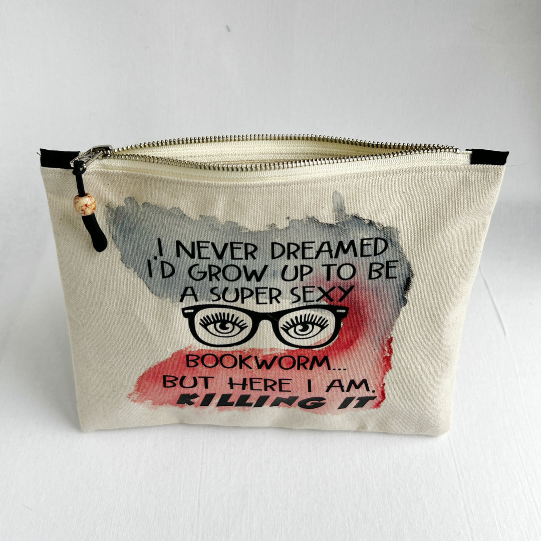 a square, linen-colored canvas zip bag, hand-sewn and hand-painted, with the words, I never dreamed I'd grow up to be a super sexy bookworm, but here I am, killing it.