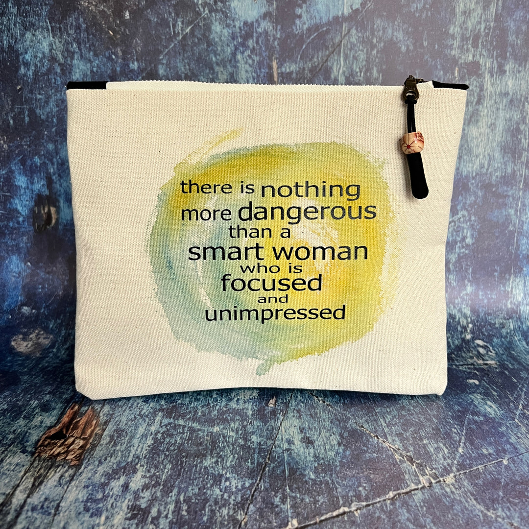 a square canvas zipper bag with the words, there is nothing more dangerous than a smart woman who is focused and unimpressed