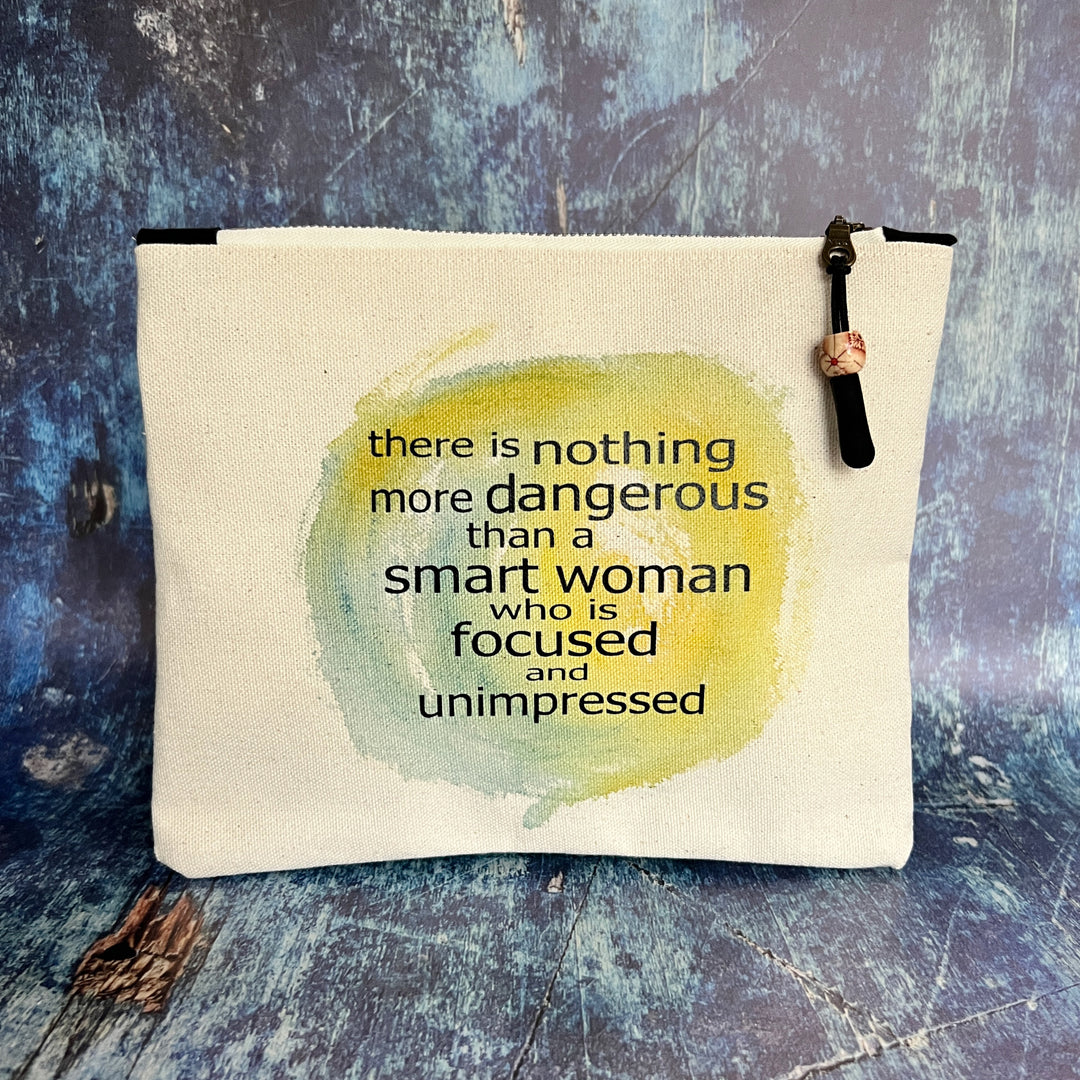 a square canvas zipper bag with the words, there is nothing more dangerous than a smart woman who is focused and unimpressed