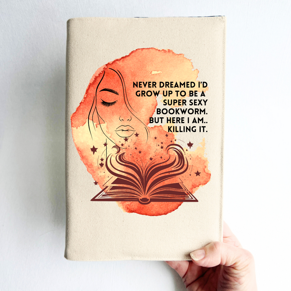 a hand holding a book covered with a linen-colored canvas with a vibrant orange-yellow watercolor swash, featuring the outline of a face with long lashes and lush lips, an open book with stars and flourishes, and the words, 'never dreamed I'd grow up to be a super sexy bookworm. but here I am, killing it.' 