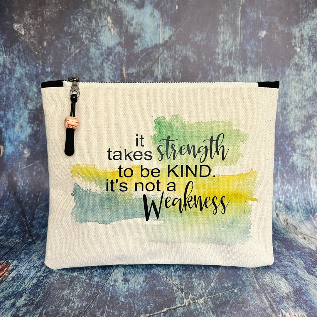 square canvas zipper pull bag with the words, it takes strength to be kind, it's not a weakness.