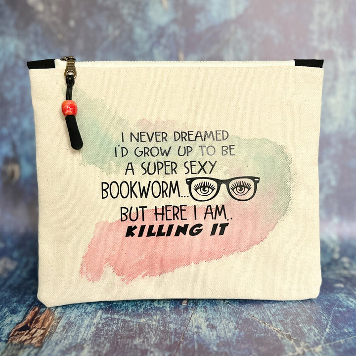 9x7 inch canvas bag with a zipper pull, watercolor paint swashes and the words, "I never dreamed I'd grow up to be a super sexy bookworm..but here I am..killing it."