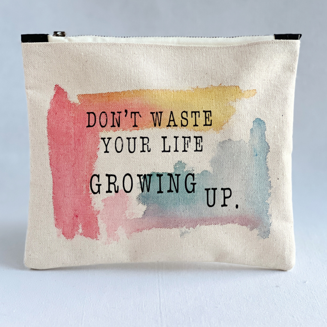 square canvas bag with paint swashes of pink, yellow and mayan blue, with the words, don't waste your life growing up.