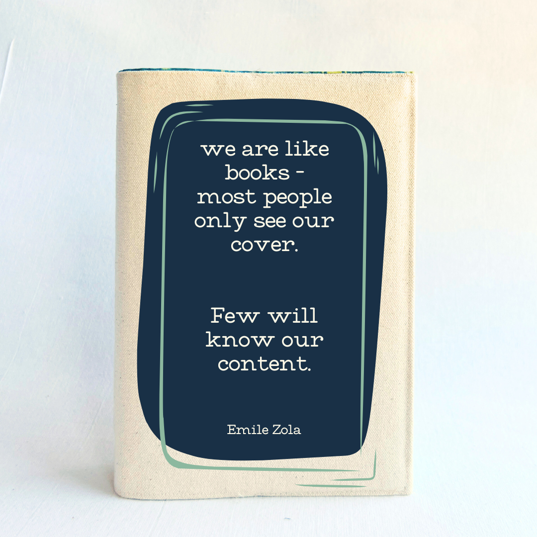 a book covered with a linen-colored canvas reusable book cover.  A rectangular design in navy tops the cover, with the words, 'we are like books - most people only see our cover.  Few will know our content.' a quote by Emile Zola, done in white lettering.