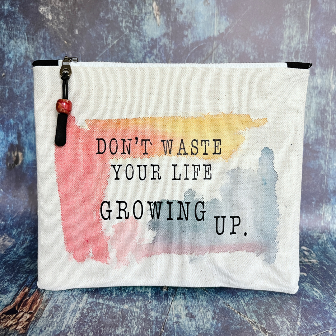 square canvas bag with paint swashes of pink, yellow and mayan blue, with the words, don't waste your life growing up.