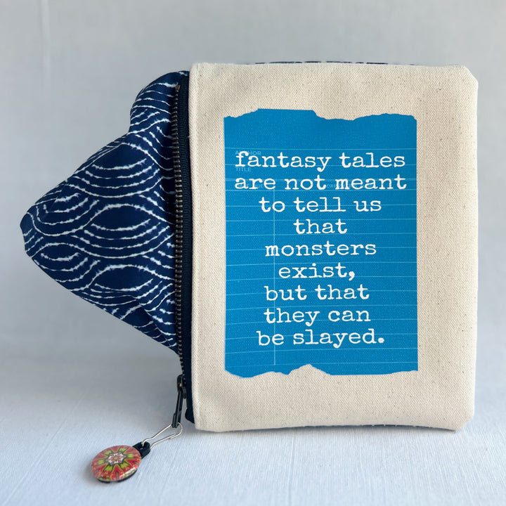 padded canvas zip bag with a blue  library card and the words, Fantasy Tales are not meant to tell us that monsters exist, but that they can be slayed, plus a colorful zipper pull and lining