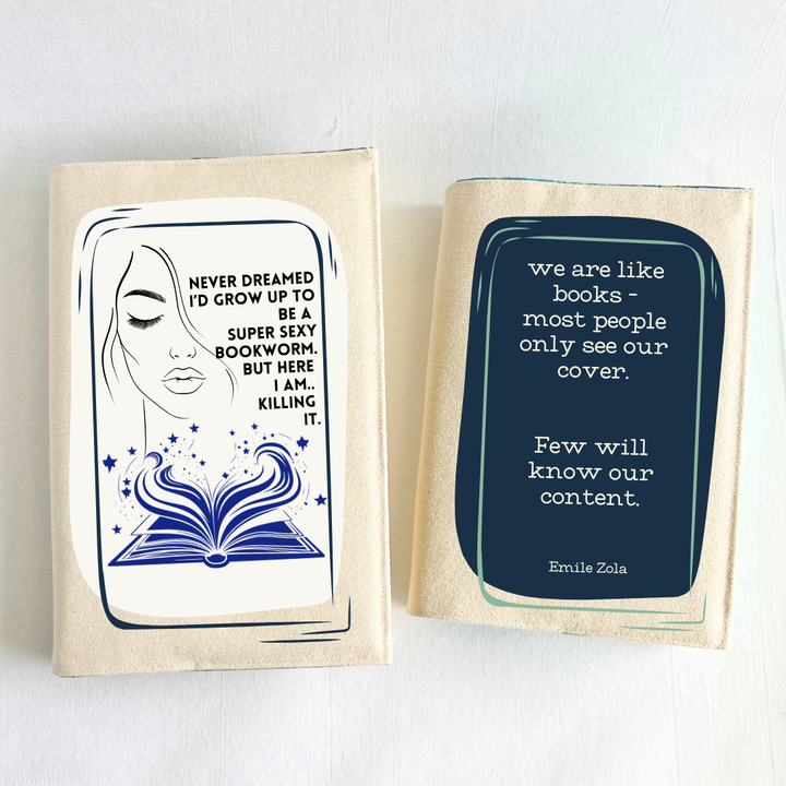 a book covered with a linen-colored canvas reusable book cover.  A rectangular design in navy tops the cover, with the words, 'we are like books - most people only see our cover.  Few will know our content.' a quote by Emile Zola, done in white lettering.  a second book is covered with canvas and a design with a woman's face, an open book with stars and flourishes, and the words, 'never dreamed I'd grow up to be a super sexy bookworm. But here I am..killing it.' Pictured as a display of a combo of covers.