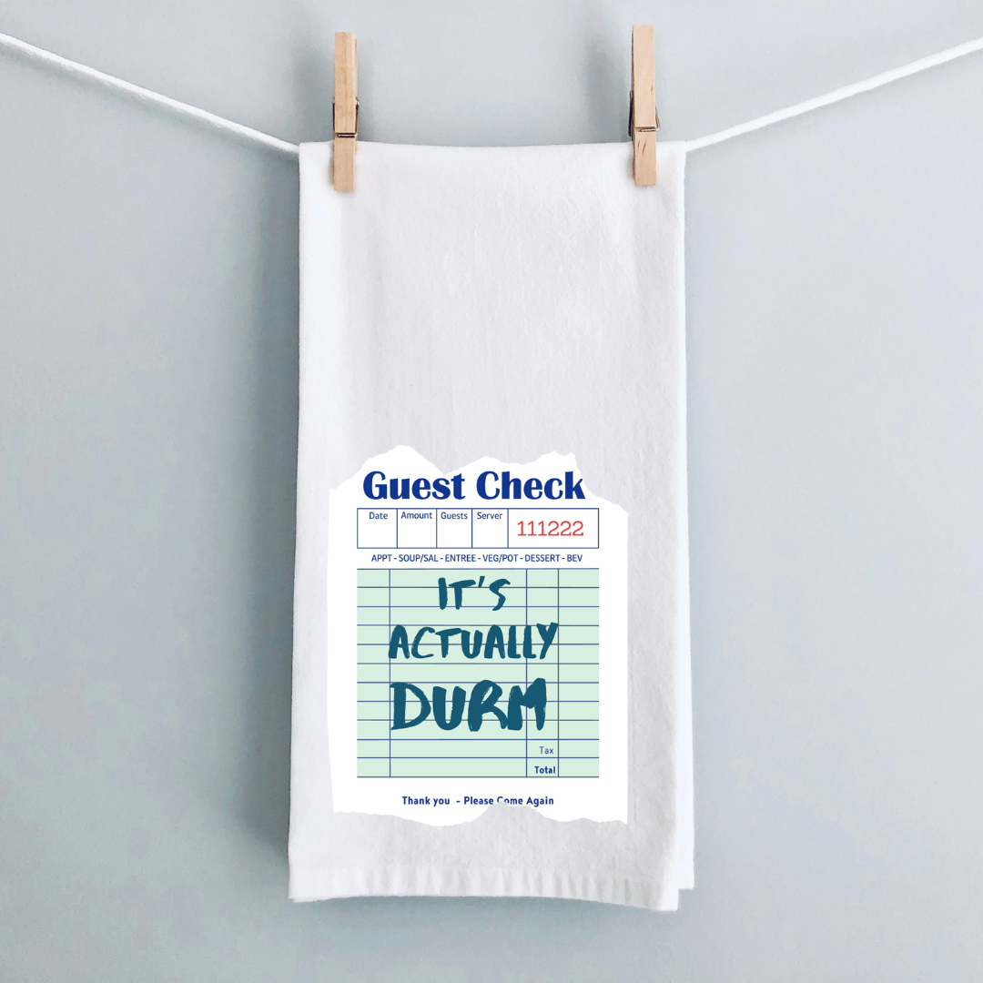 A white kitchen towel with a vintage guest check design in green and the words, it's actually DURM