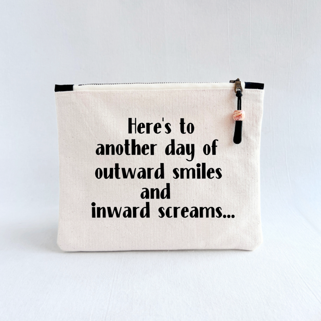 square canvas zip pouch with the words, Here's to another day of outward smiles and inward screams.'
