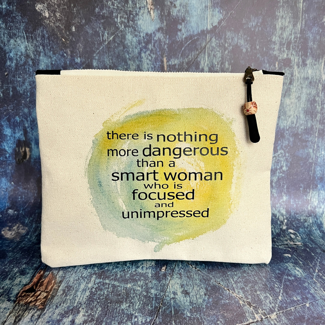 a square canvas zipper bag with the words, there is nothing more dangerous than a smart woman who is focused and unimpressed