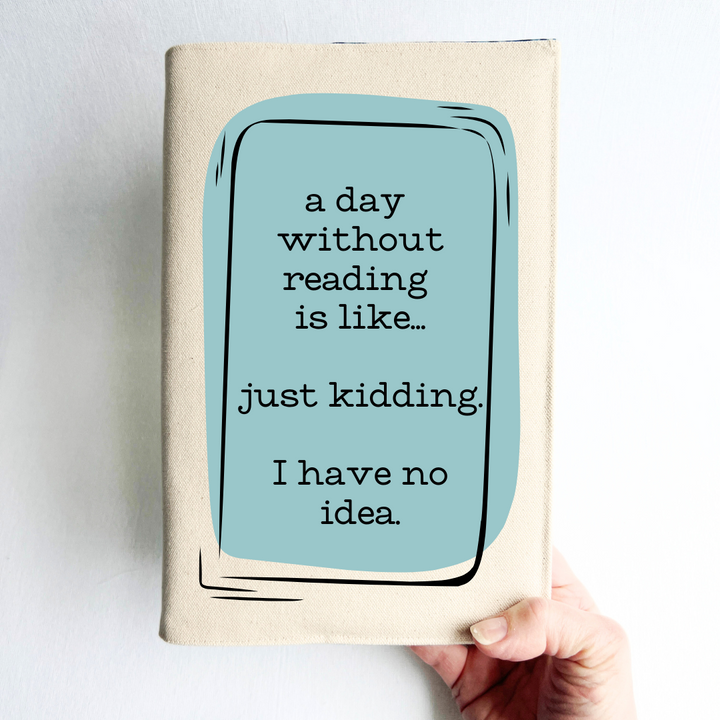 a hand holding a book covered with a reusable book cover in linen, with the words, 'a day without reading is like.. just kidding. I have no idea. ' in black lettering, placed on a rectangular light blue box design.