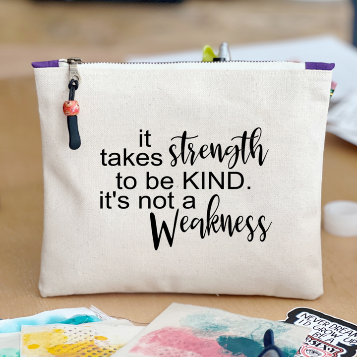 square canvas zipper pull bag with the words, it takes strength to be kind, it's not a weakness.