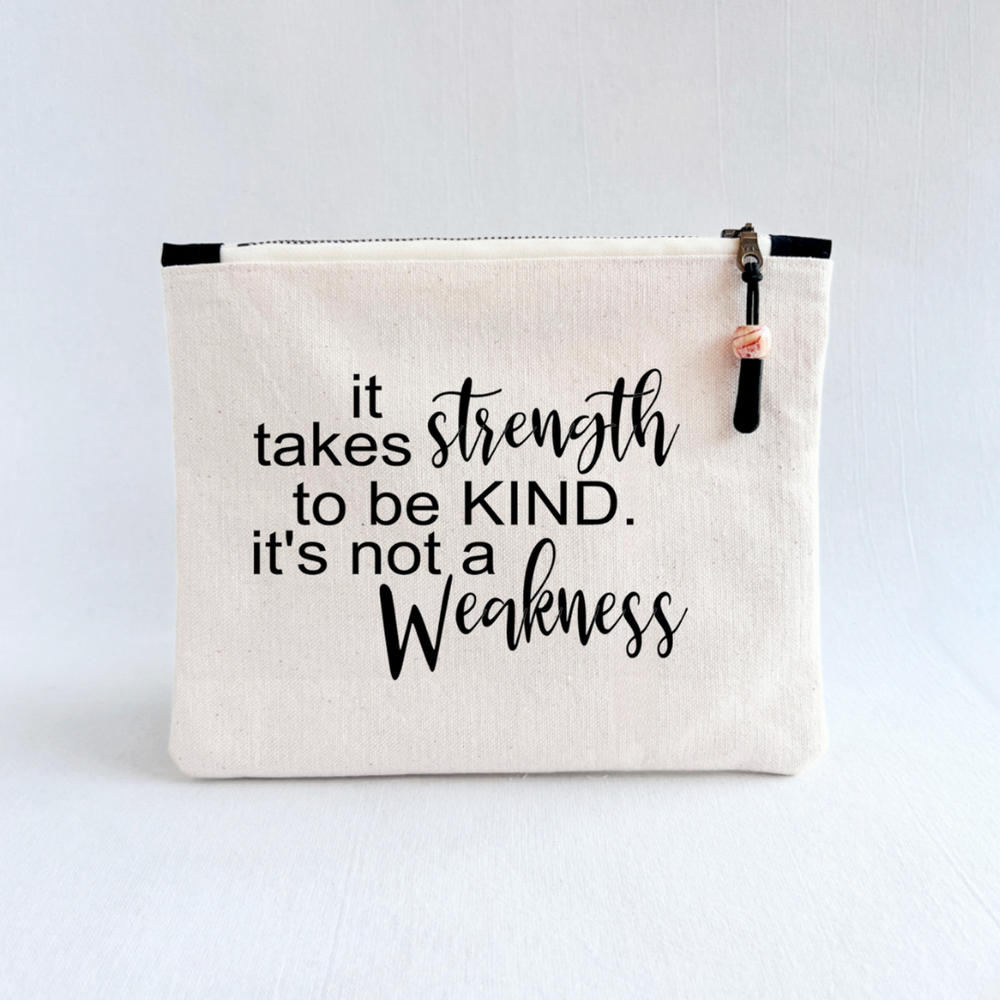 square canvas zipper pull bag with the words, it takes strength to be kind, it's not a weakness.