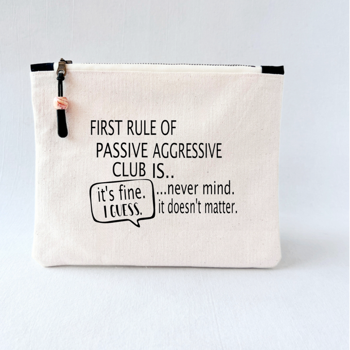 a canvas zip bag with blue watercolor painting and the words, "First rule of passive aggressive club is..never mind. it doesn't matter. it's fine. I guess."