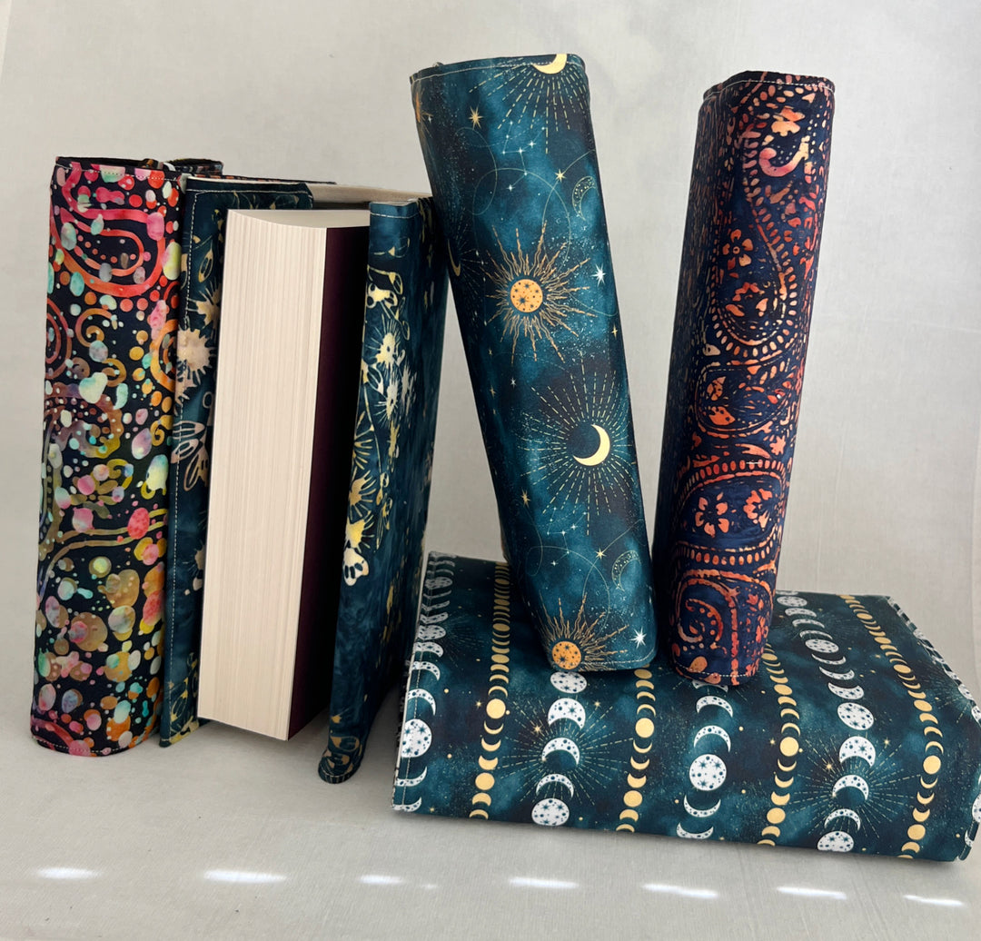 a stack of book covers made in rich, luscious fall colors of deep orange, blue-greys and paisley multicolors