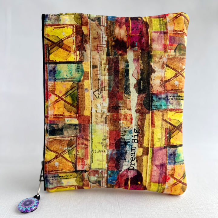 square oblong bag in colorful multicolored fabric with a zipper pull.