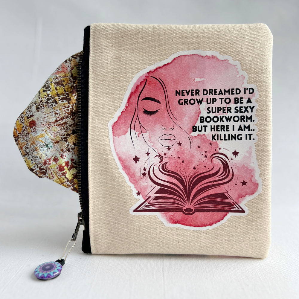 square oblong canvas zipper bag with a design of a face and an open book, with the words, "Never dreamed I'd grow up to be a super sexy bookworm. But here I am..killing it."