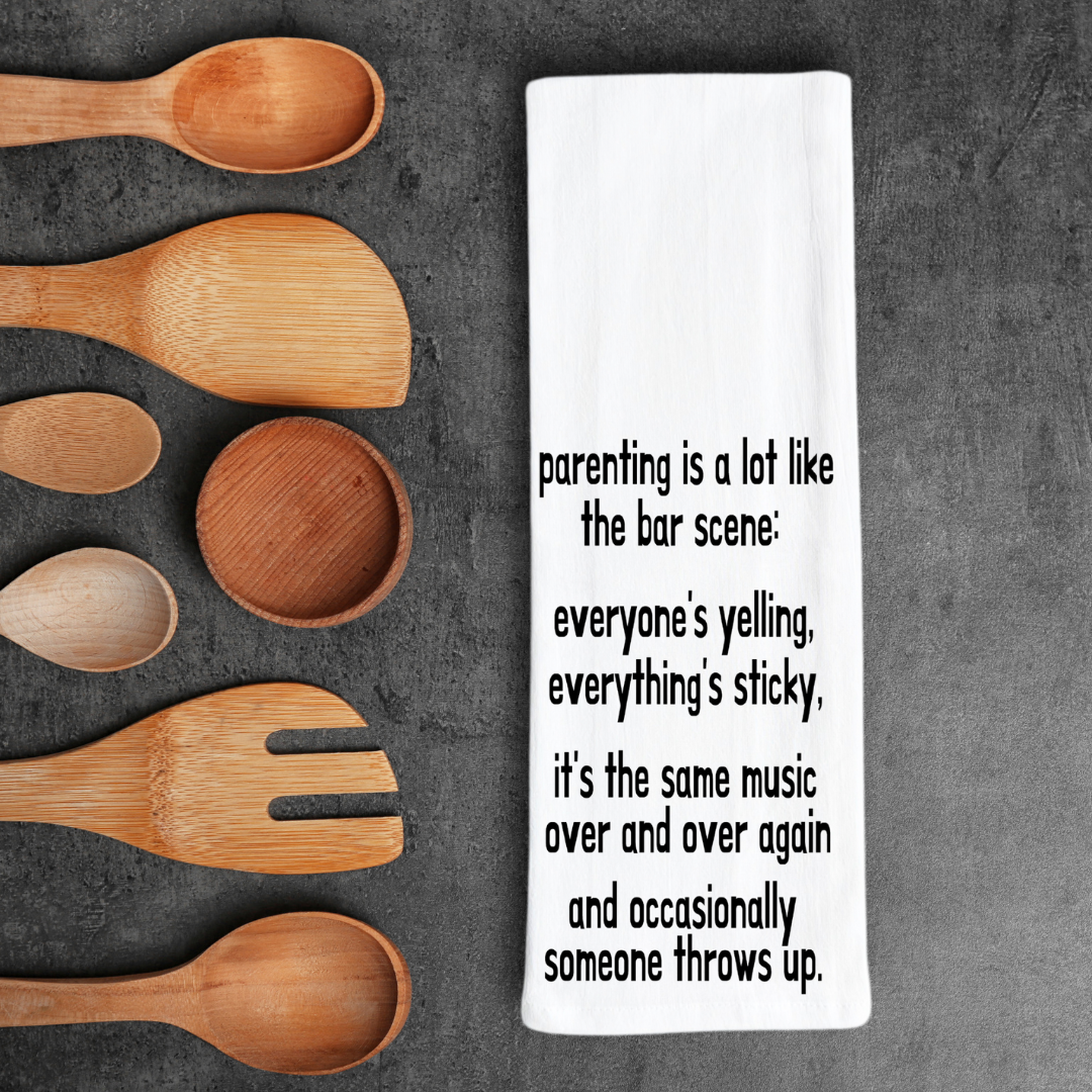 rectangular white kitchen towel with the words, parenting is lot like the bar scene: everyone's yelling, everything's sticky, it's the same music over and over again and occasionally someone throws up.
