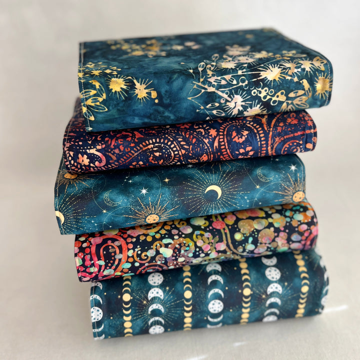 a stack of book covers made in rich, luscious fall colors of deep orange, blue-greys and paisley multicolors
