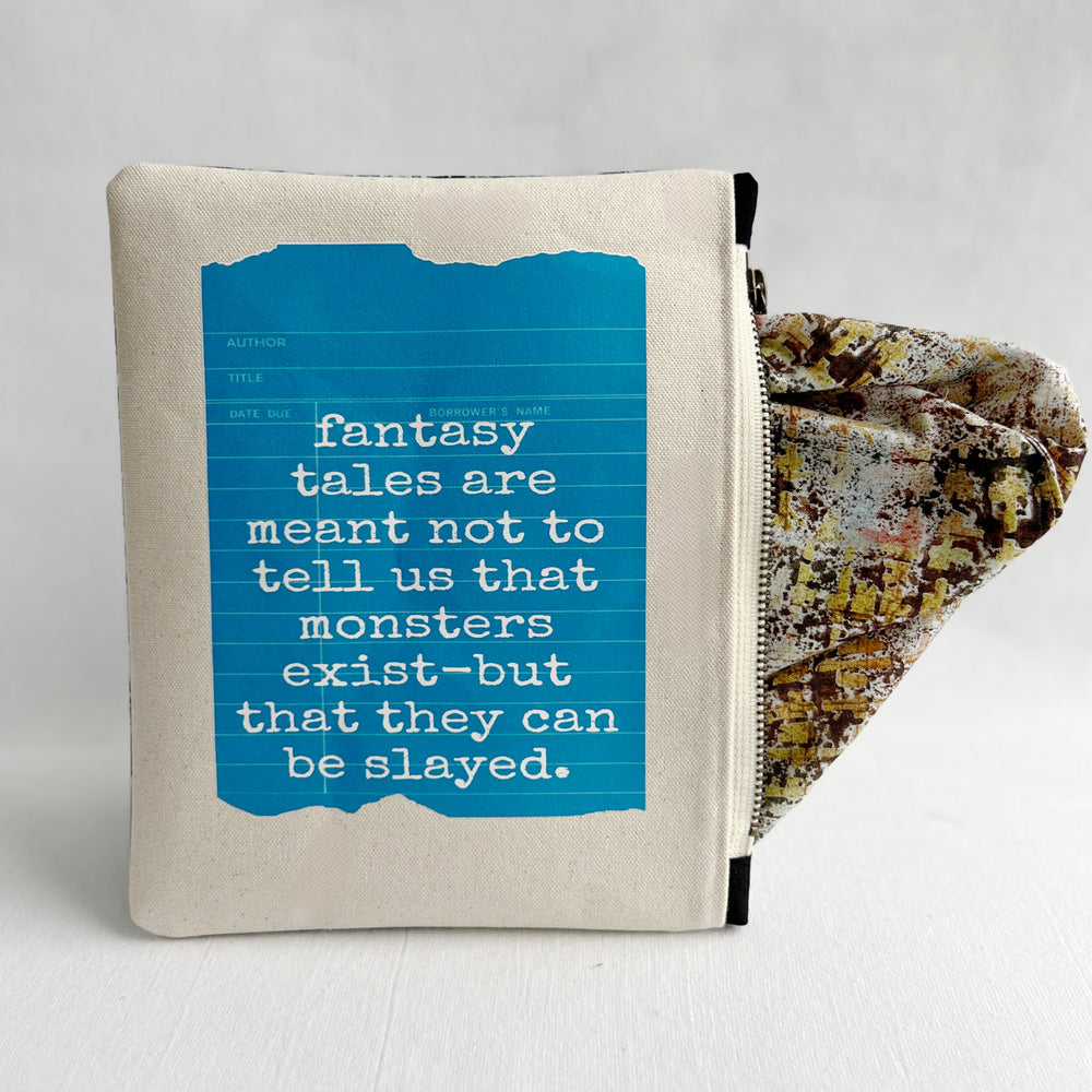 padded canvas zip bag with a blue  library card and the words, Fantasy Tales are not meant to tell us that monsters exist, but that they can be slayed, plus a colorful zipper pull and lining