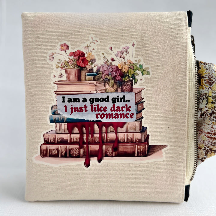 square canvas zip bag with lining and a design of stacked books, flowers, and the words, "I am a good girl..I just like dark romance."