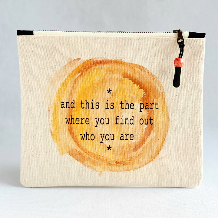 canvas zip bag measuring 9x7 inches, with  the words, "and this is the part where you find out who you are" in black lettering.