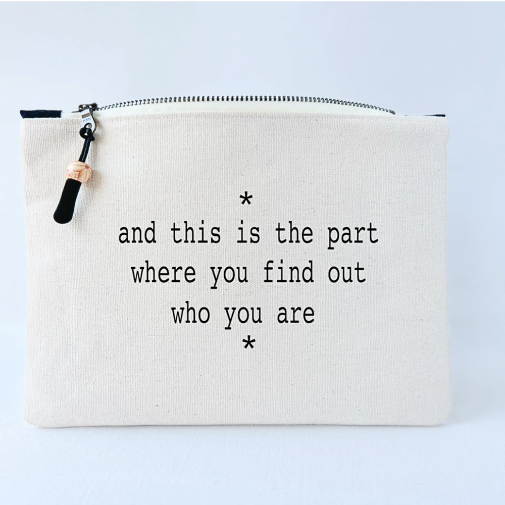 canvas zip bag measuring 9x7 inches, with  the words, "and this is the part where you find out who you are" in black lettering.