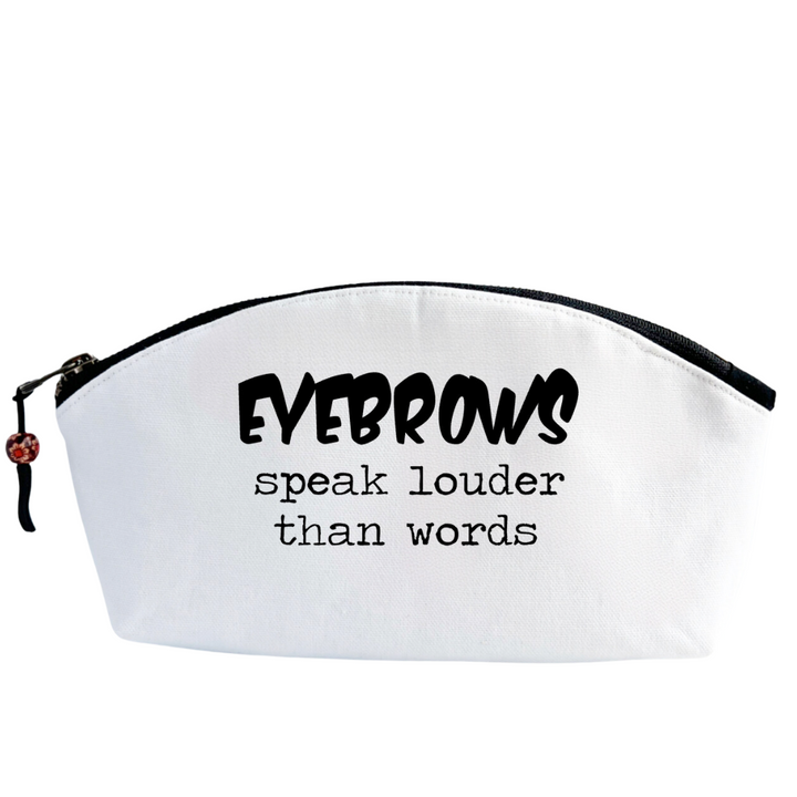 white canvas cosmetic bag with a curvy top, black zipper and the words, eyebrows speak louder than words.