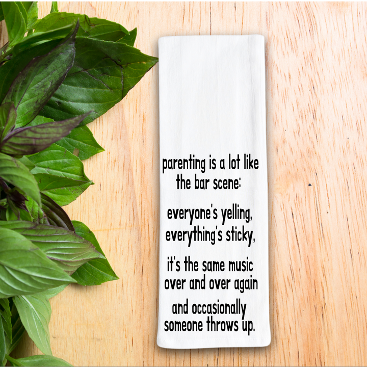 rectangular white kitchen towel with the words, parenting is lot like the bar scene: everyone's yelling, everything's sticky, it's the same music over and over again and occasionally someone throws up.