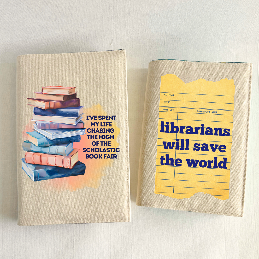 Canvas, reusable book covers in linen, one with the words,  I've spent my life chasing the high of the scholastic book fair' in navy lettering on a watercolor swoosh, next to a stack of books rendered in watercolor-painting style. The other has a vintage-style library checkout card with the words, 'librarians will save the world.'